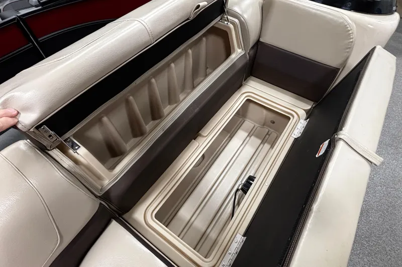 Slide: The Image of 2018 Sun Tracker Party Barge 20 DLX storage compartment with beige seating. - 24