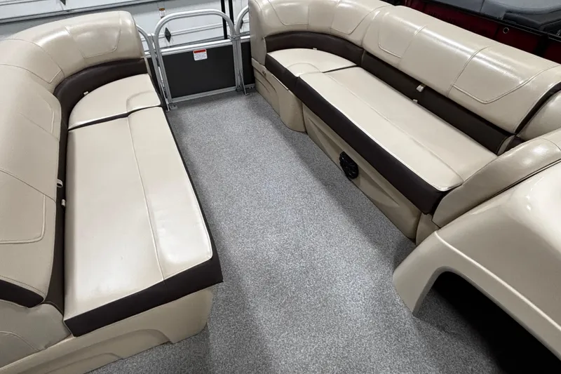 Slide: The Image of 2018 Sun Tracker Party Barge 20 DLX interior with beige seating and gray carpet. - 3