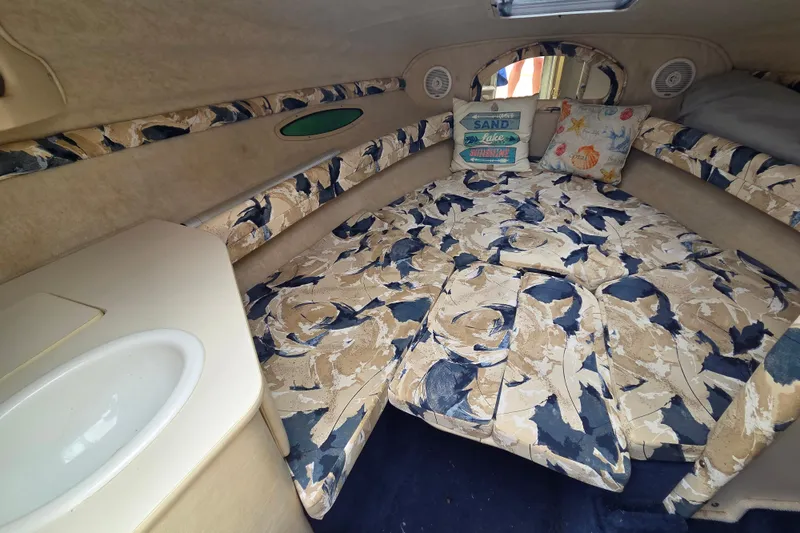 Slide: The Image of Interior of 2000 Sea Ray 215 Express Cruiser with patterned upholstery and cozy cabin space. - 6