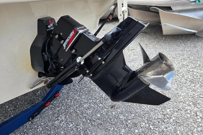 Slide: The Image of Mercury outboard motor on 2000 Sea Ray 215 Express Cruiser, displayed on gravel surface. - 8