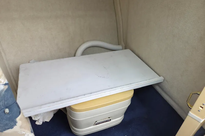 Slide: The Image of Interior of 2000 Sea Ray 215 Express Cruiser with portable toilet and storage area. - 9