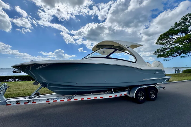 Slide: The Image of 2027 Scout 288 Dorado boat on trailer under blue sky with clouds. - 1