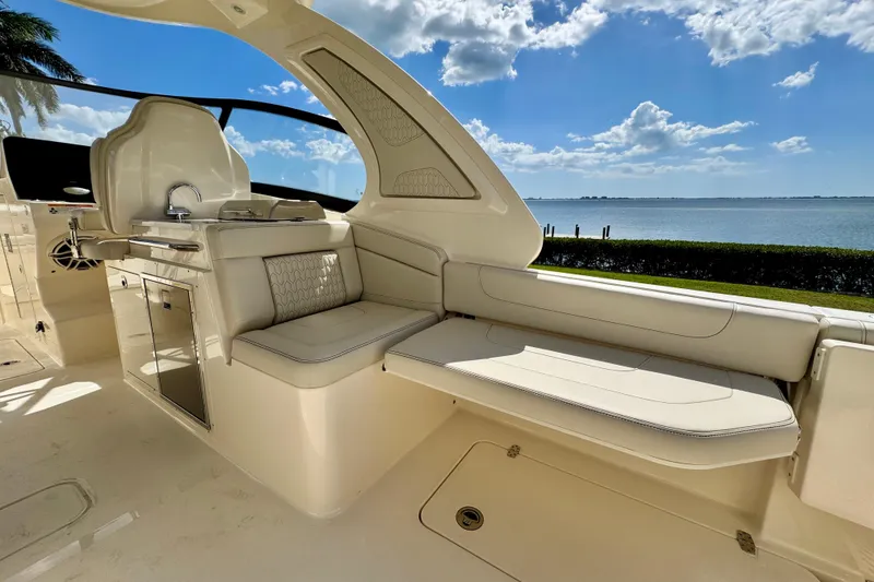 Slide: The Image of Luxurious interior of 2027 Scout 288 Dorado boat with seating and kitchenette, overlooking serene water. - 14