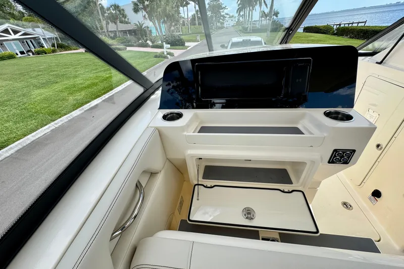 Slide: The Image of Interior view of 2027 Scout 288 Dorado boat dashboard with modern controls and scenic background. - 26