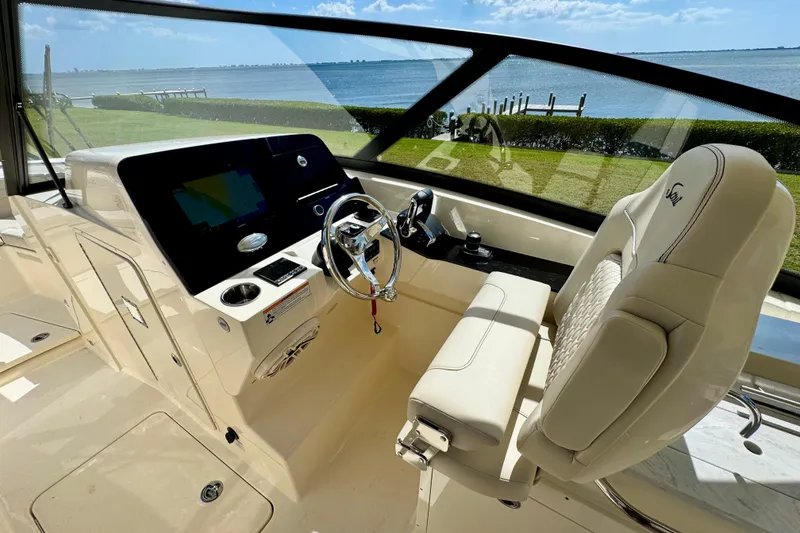 Slide: The Image of 2027 Scout 288 Dorado boat cockpit with steering wheel and navigation display. - 28