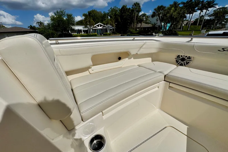 Slide: The Image of Luxurious seating on a 2027 Scout 288 Dorado boat, featuring beige upholstery and cup holders. - 33