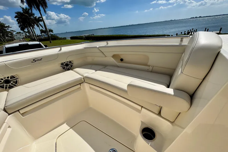 Slide: The Image of 2027 Scout 288 Dorado boat interior with beige seating, near waterfront view. - 34