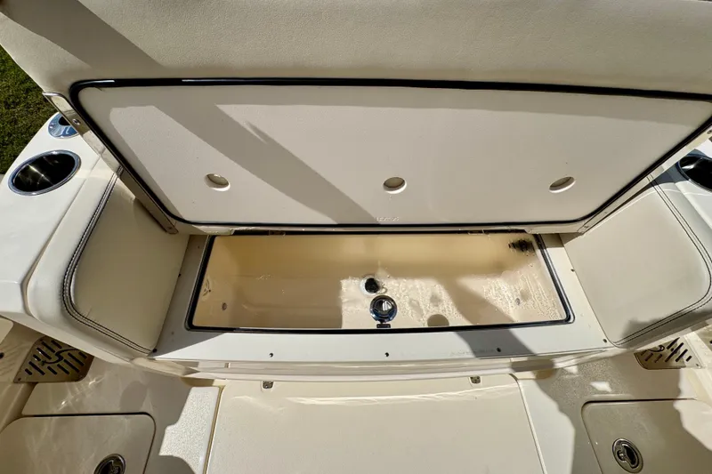 Slide: The Image of Open storage compartment on 2027 Scout 288 Dorado boat, featuring cup holders and seating. - 8
