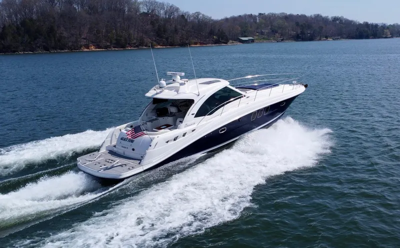 Slide: The Image of 2006 Sea Ray 48 Sundancer yacht cruising on a scenic lake. - 11