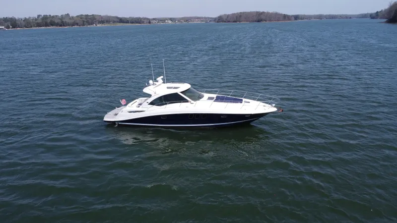 Slide: The Image of 2006 Sea Ray 48 Sundancer yacht cruising on a calm lake. - 14