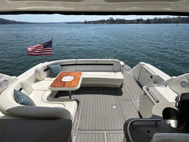 Slide: The Image of 2006 Sea Ray 48 Sundancer yacht with spacious deck, American flag, and scenic water view. - 18