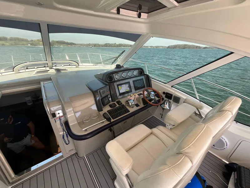 Slide: The Image of 2006 Sea Ray 48 Sundancer helm with modern controls, overlooking serene waters. - 21