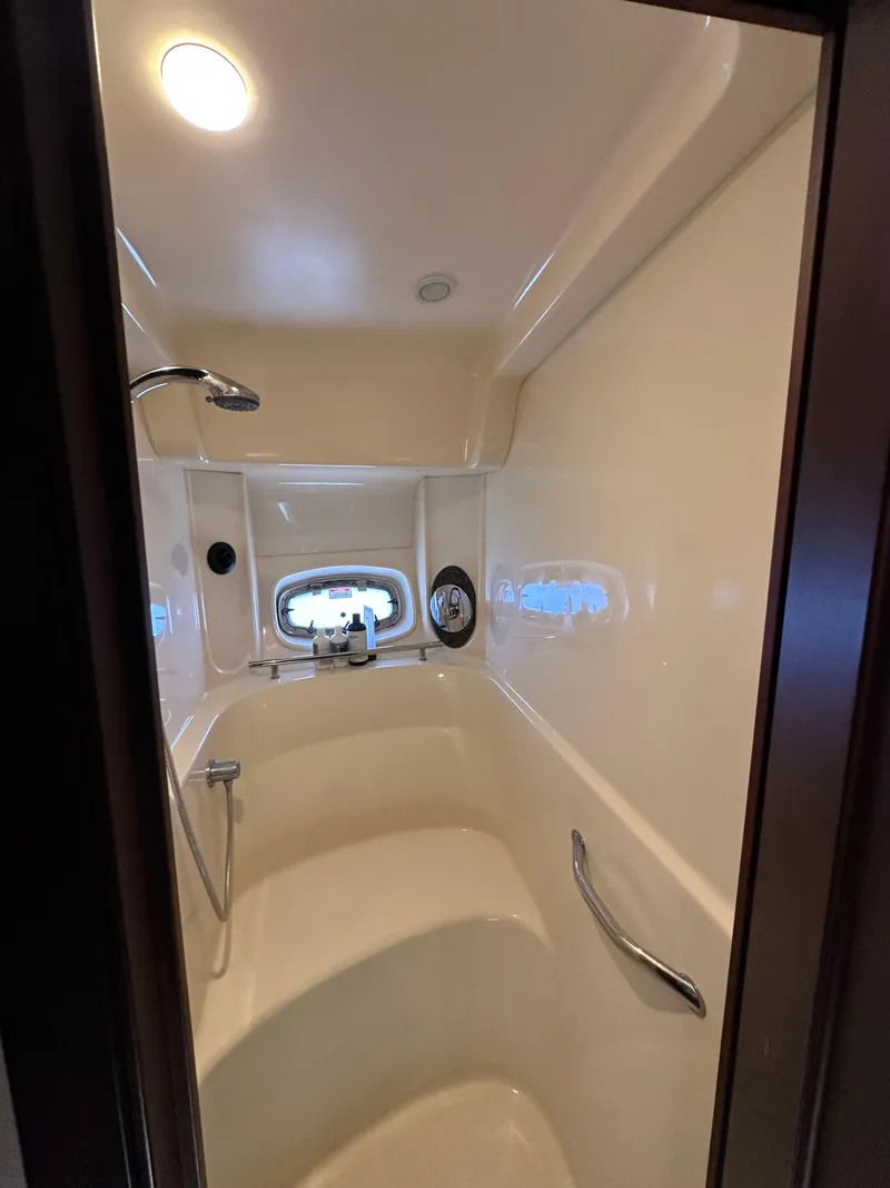 Slide: The Image of 2006 Sea Ray 48 Sundancer shower interior with modern fixtures and porthole window. - 25