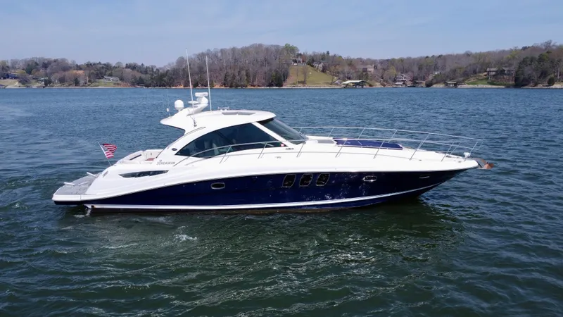 Slide: The Image of 2006 Sea Ray 48 Sundancer yacht cruising on a serene lake. - 4