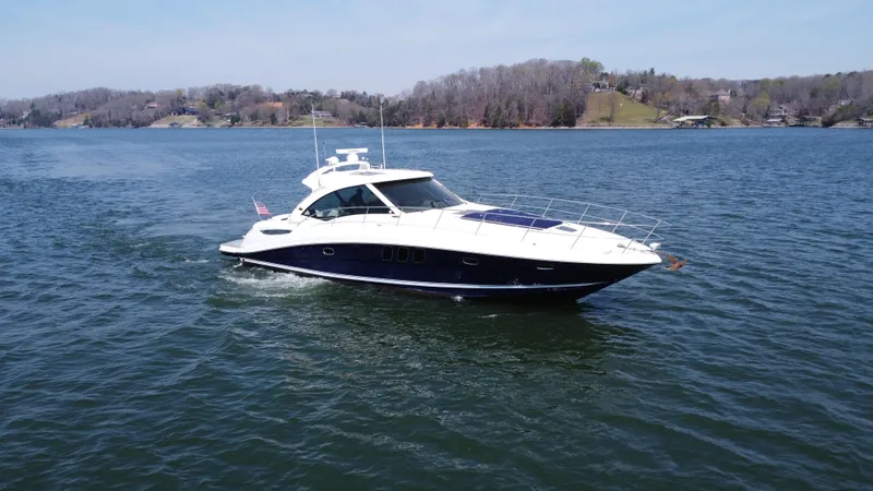 Slide: The Image of 2006 Sea Ray 48 Sundancer yacht cruising on a serene lake. - 8