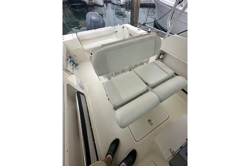 Slide: The Image of 2007 Pursuit 235 Denali LS boat interior with cushioned seating and docked in marina. - 13