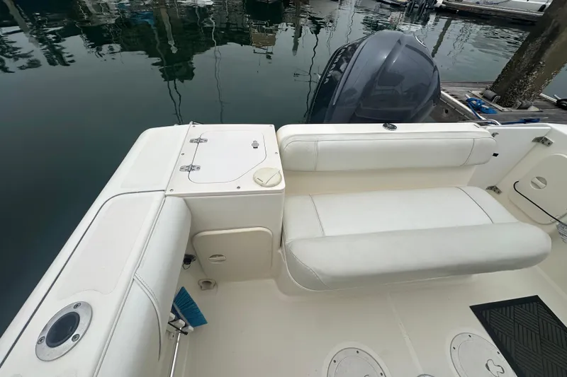 Slide: The Image of 2007 Pursuit 235 Denali LS boat interior with seating and motor at dock. - 14