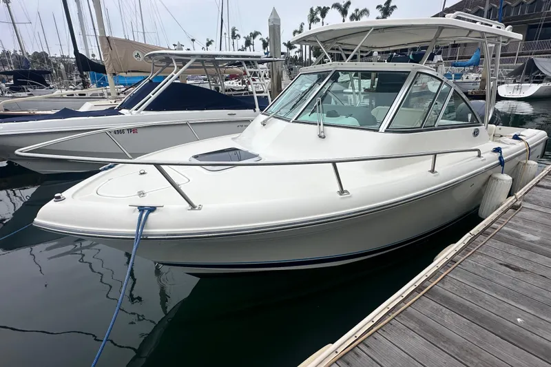 Slide: The Image of 2007 Pursuit 235 Denali LS boat docked at marina, featuring sleek design and white exterior. - 17