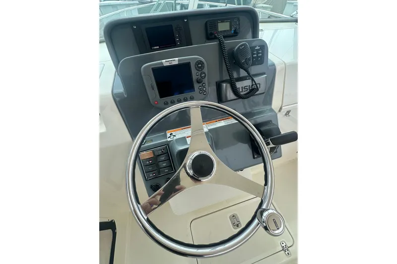 Slide: The Image of Helm of 2007 Pursuit 235 Denali LS boat with steering wheel and navigation controls. - 7