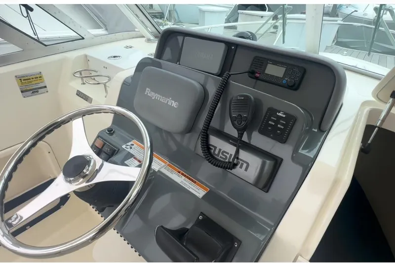 Slide: The Image of 2007 Pursuit 235 Denali LS boat dashboard with steering wheel and navigation equipment. - 8