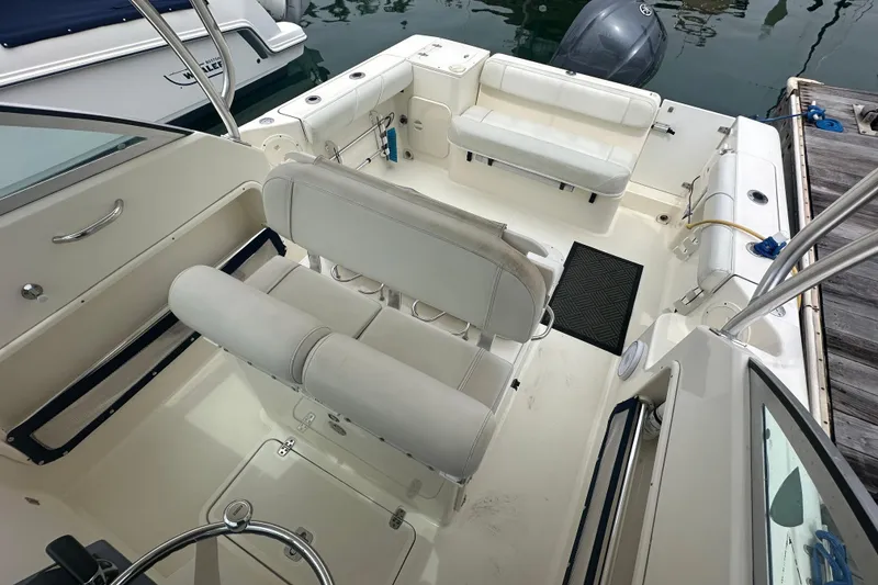 Slide: The Image of 2007 Pursuit 235 Denali LS boat interior with white seating and steering wheel. - 9