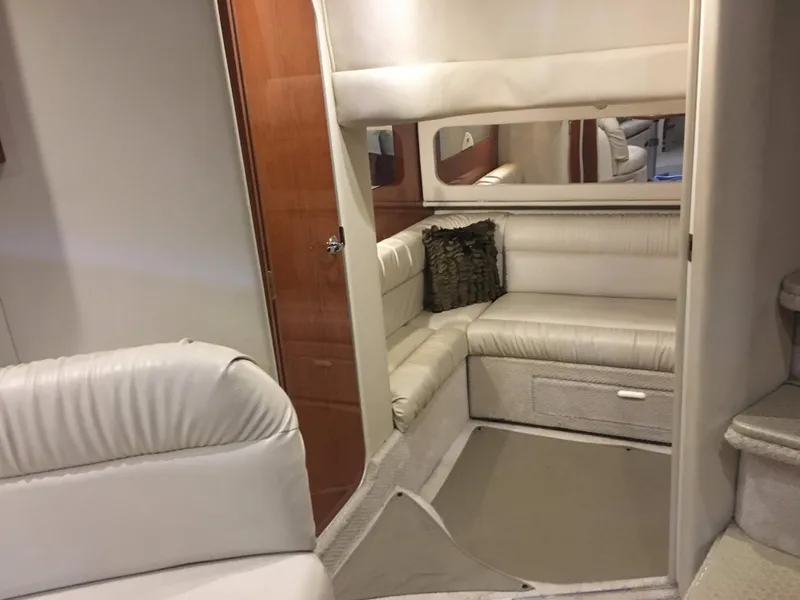 Slide: The Image of Interior of 2000 Sea Ray 410 Sundancer with white leather seating and wood accents. - 30