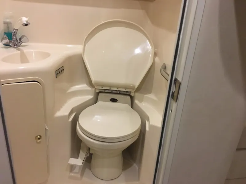 Slide: The Image of Bathroom interior of 2000 Sea Ray 410 Sundancer yacht, featuring a compact toilet and sink. - 44