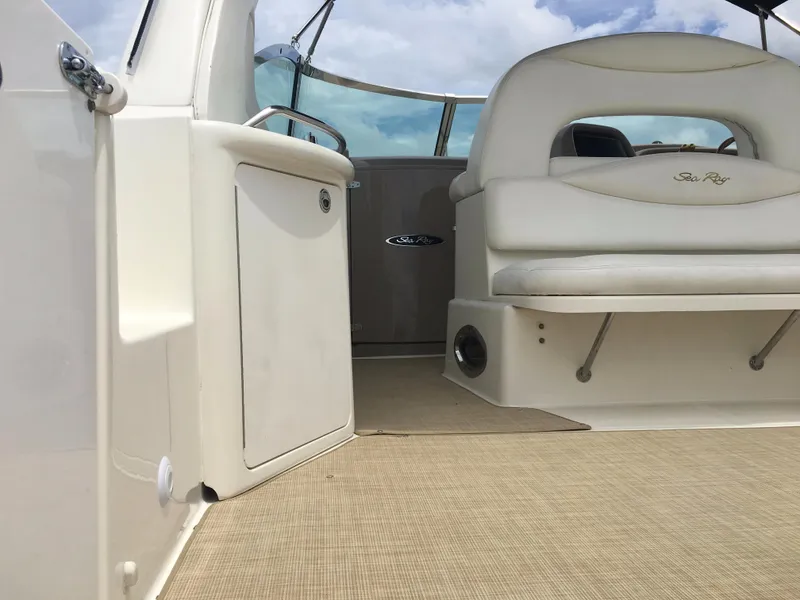 Slide: The Image of 2000 Sea Ray 410 Sundancer boat interior with white seating and beige flooring. - 9