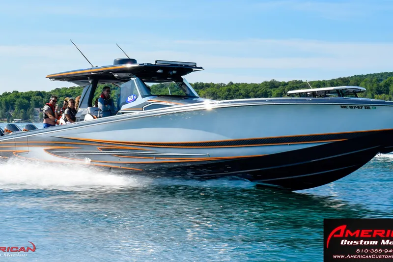 Slide: The Image of 2027 Nor-Tech 450 Sport Center Console cruising on a lake with passengers onboard. - 1