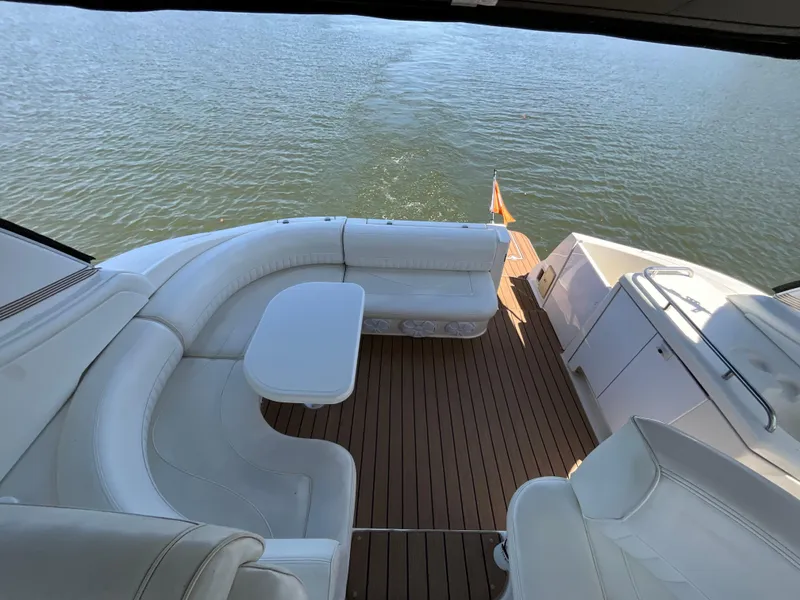 Slide: The Image of 2004 Cruisers Yachts 370 Express with white seating and wooden deck on open water. - 15