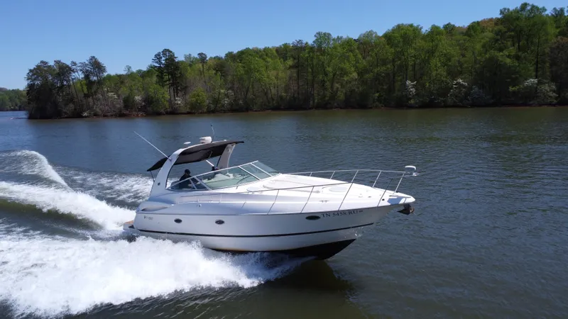 Slide: The Image of 2004 Cruisers Yachts 370 Express cruising on a scenic lake with lush green trees. - 4