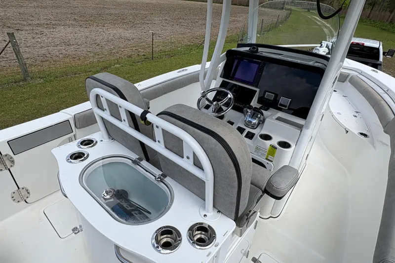 Slide: The Image of 2021 Sea Pro 259 DLX boat interior with helm, seating, and fishing amenities. - 13