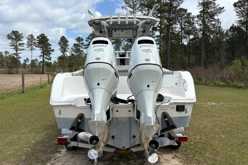 Slide: The Image of 2021 Sea Pro 259 DLX boat with dual outboard engines, parked on grass. - 18