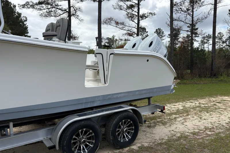Slide: The Image of 2021 Sea Pro 259 DLX boat on trailer, parked outdoors near trees. - 3