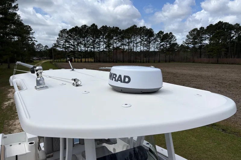 Slide: The Image of 2021 Sea Pro 259 DLX boat with radar on top, surrounded by trees and cloudy sky. - 7