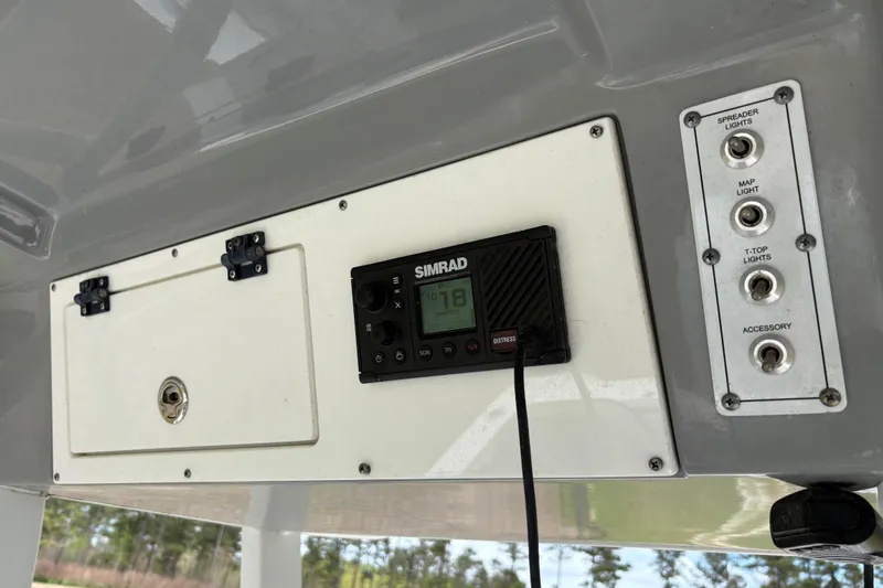 Slide: The Image of 2021 Sea Pro 259 DLX boat dashboard with Simrad radio and light switches. - 9