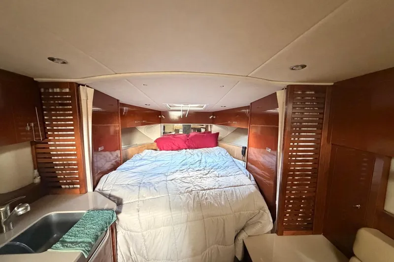 Slide: The Image of Interior cabin of 2010 Sea Ray 370 Express Cruiser with cozy bed and wooden finishes. - 14