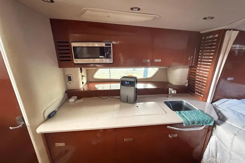 Slide: The Image of Interior of 2010 Sea Ray 370 Express Cruiser kitchen with microwave and sink. - 15