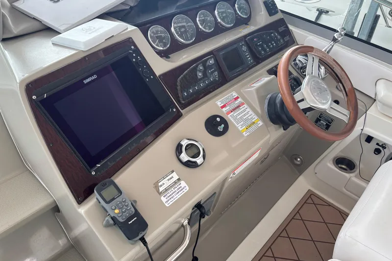 Slide: The Image of Cockpit of 2010 Sea Ray Sundancer 370 with steering wheel and navigation controls. - 18
