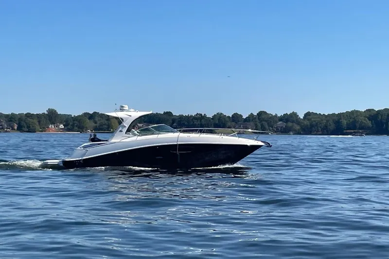 Slide: The Image of 2010 Sea Ray 370 Express Cruiser on a calm lake under clear blue skies. - 2
