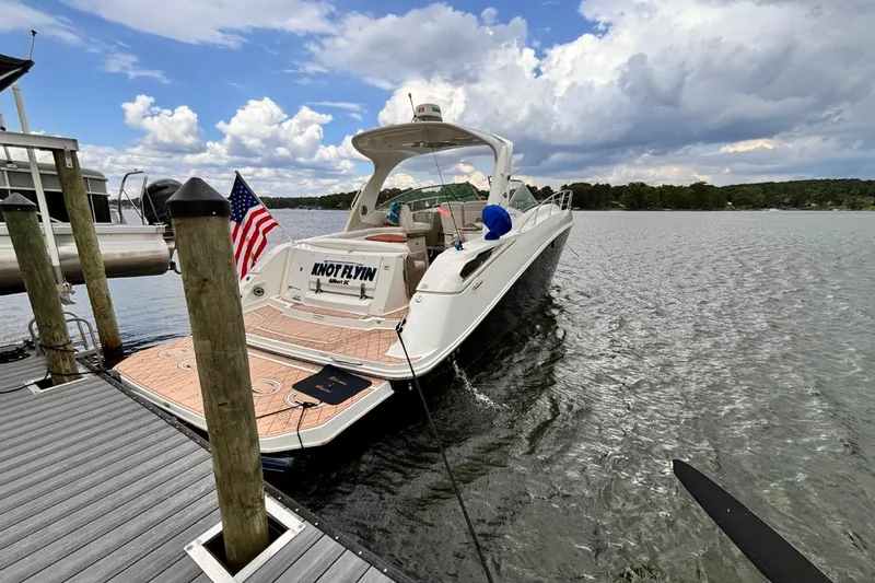 Slide: The Image of 2010 Sea Ray 370 Express Cruiser docked on a lake with American flag. - 3