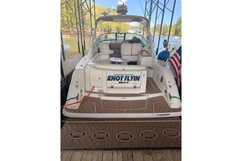 Slide: The Image of 2010 Sea Ray 370 Express Cruiser docked, featuring spacious deck and American flag. - 8