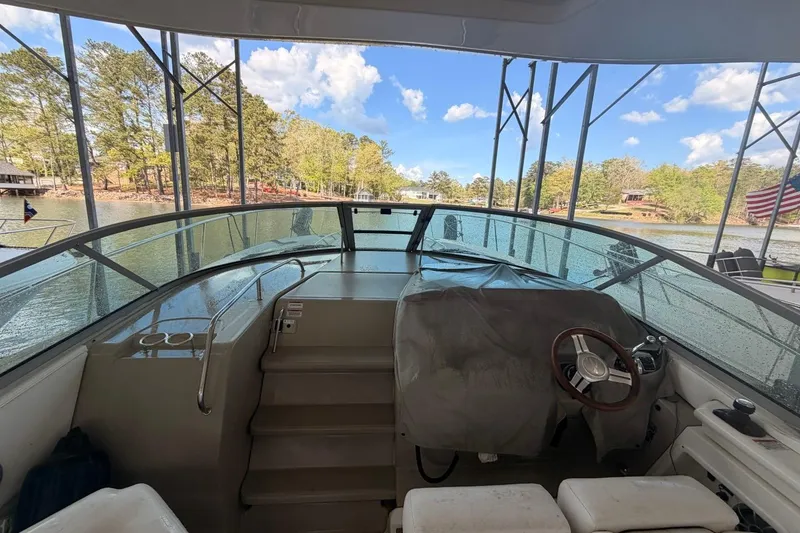 Slide: The Image of 2010 Sea Ray 370 Express Cruiser helm with scenic lake view and clear blue sky. - 9