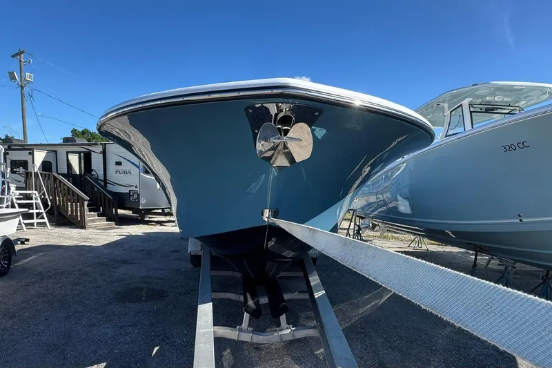 Slide: The Image of 2026 Tidewater 302 CC Adventure boat on trailer, displayed outdoors under clear blue sky. - 1