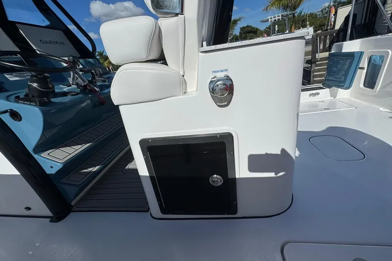 Slide: The Image of 2026 Tidewater 302 CC Adventure boat interior with fresh water access and seating. - 14