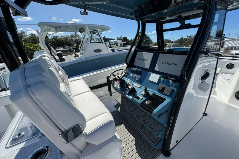 Slide: The Image of 2026 Tidewater 302 CC Adventure boat cockpit with dual Garmin displays and plush seating. - 17