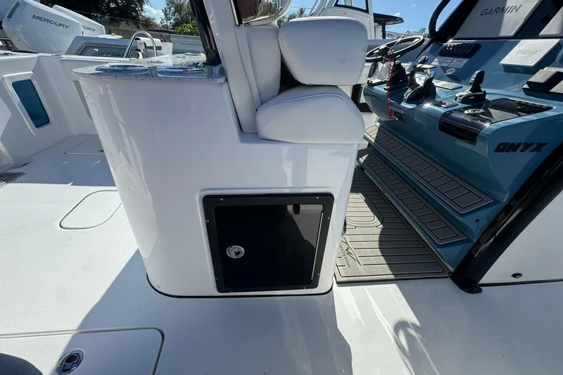 Slide: The Image of 2026 Tidewater 302 CC Adventure boat interior with helm, seating, and storage compartment. - 18