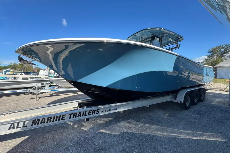 Slide: The Image of 2026 Tidewater 302 CC Adventure boat on trailer under clear blue sky. - 2