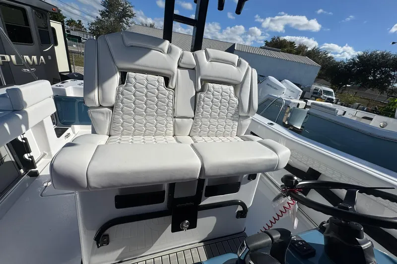 Slide: The Image of 2026 Tidewater 302 CC Adventure boat with luxurious white seating under a clear blue sky. - 20