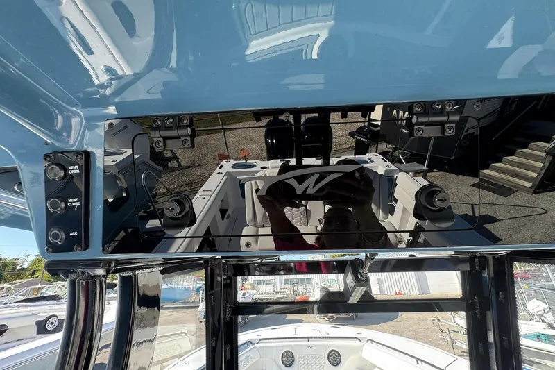 Slide: The Image of 2026 Tidewater 302 CC Adventure boat dashboard with controls and reflection. - 31